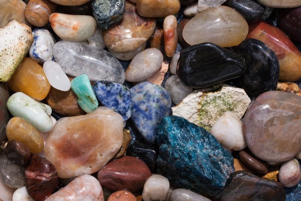 Eri kokoisia ja värisiä kiviä kasassa.