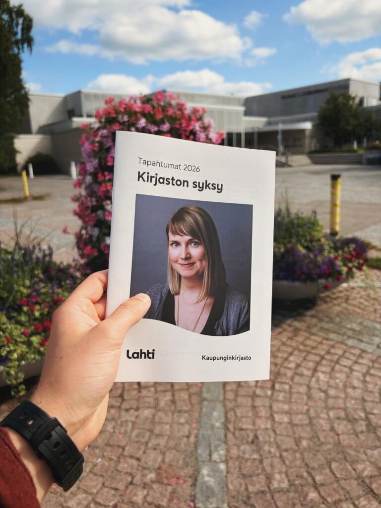Tapahtumaesitteen kansikuva pääkirjaston pihalla kuvattuna.